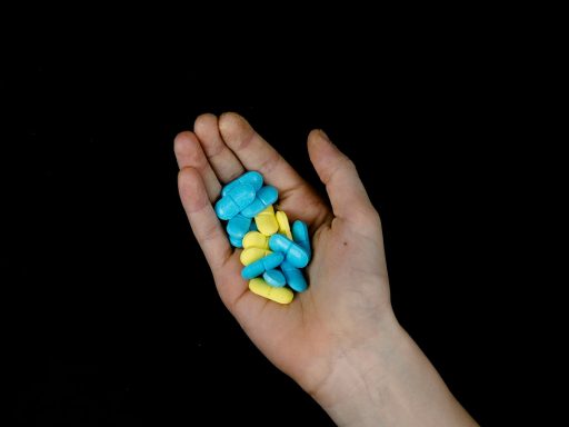 a person's hand holding a handful of pills