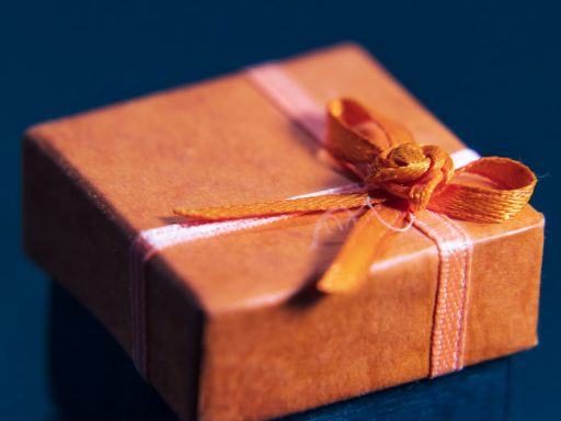 an orange wrapped gift box with a bow