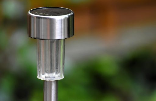 Buitenlamp op zonne-energie geplaatst langs een tuinpad
