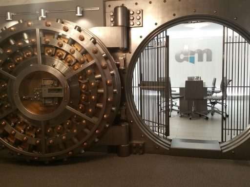 Een open kluisdeur van een bank, symbool voor het bewaren van geld