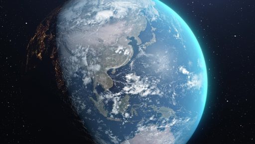 Een verlichte aardbol die ronddraait in de ruimte, zichtbaar vanuit de atmosfeer