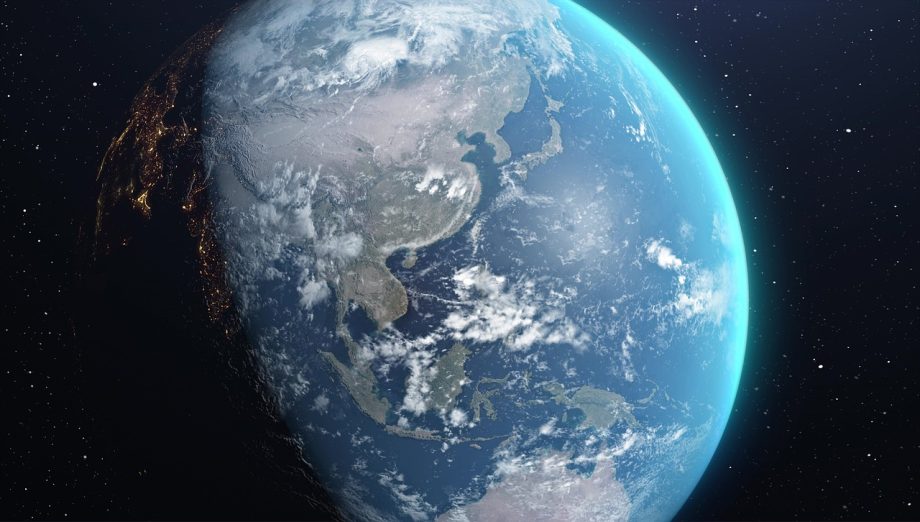 Een verlichte aardbol die ronddraait in de ruimte, zichtbaar vanuit de atmosfeer