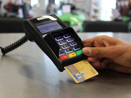Iemand die een stapel bankbiljetten bij een bankautomaat voorbereidt voor een storting
