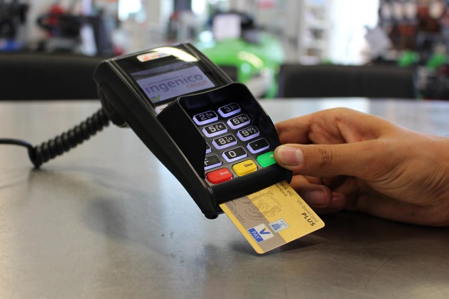 Iemand die een stapel bankbiljetten bij een bankautomaat voorbereidt voor een storting