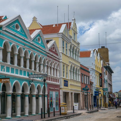 De kleurrijke historische gevels aan de Handelskade in Willemstad, Curaçao, weerspiegeld in het water van de Sint Annabaai