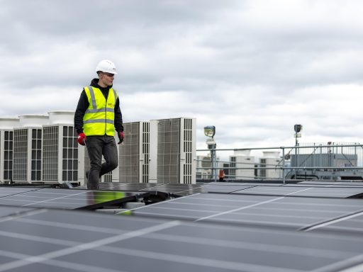 Een elektricien installeert een zonnepaneel op een dak, symbool voor praktische beroepen met toekomst