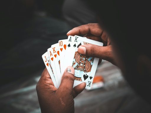 person holding 10 of diamonds and 10 of diamonds playing cards