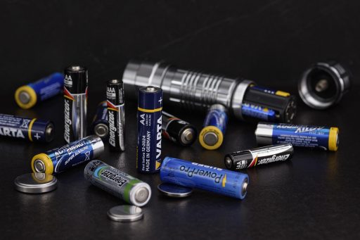 Een thuisbatterijsysteem gemonteerd aan de muur in een garage naast een elektrisch zekeringkast