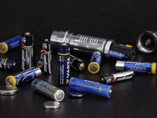 Een thuisbatterijsysteem gemonteerd aan de muur in een garage naast een elektrisch zekeringkast