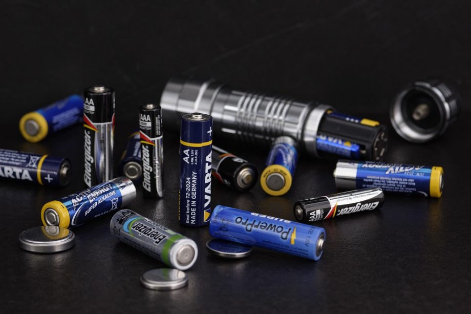 Een thuisbatterijsysteem gemonteerd aan de muur in een garage naast een elektrisch zekeringkast