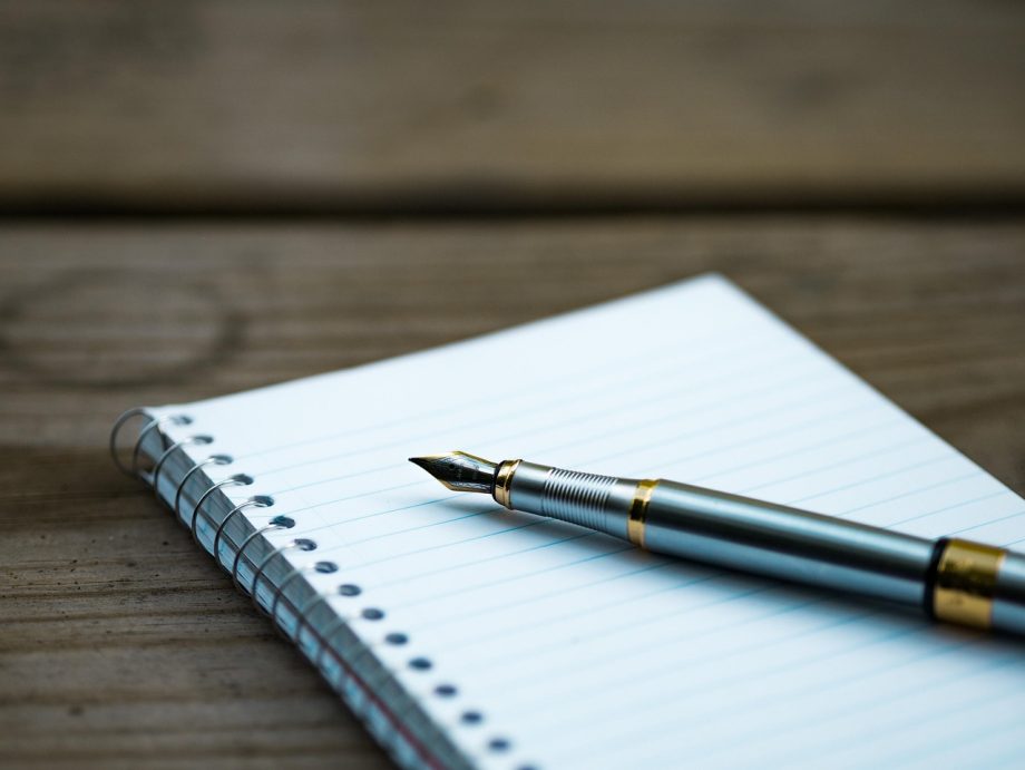 Notitieboek met aantekeningen over gewoonten naast een pen op een bureau