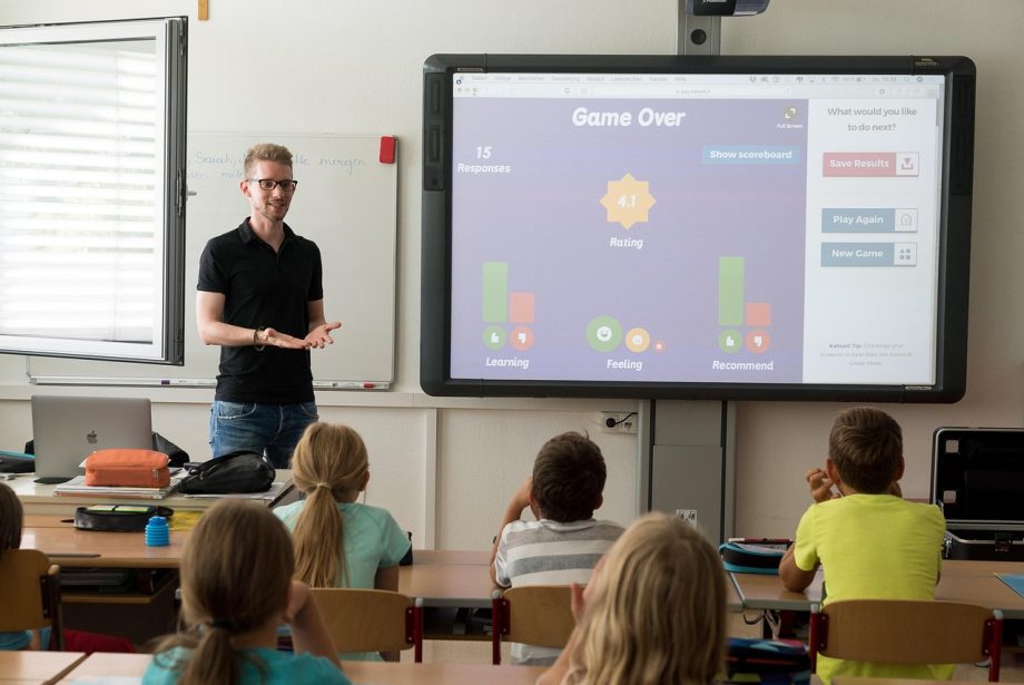 Een begeleider geeft gerichte feedback aan een student na een presentatie in een klaslokaal